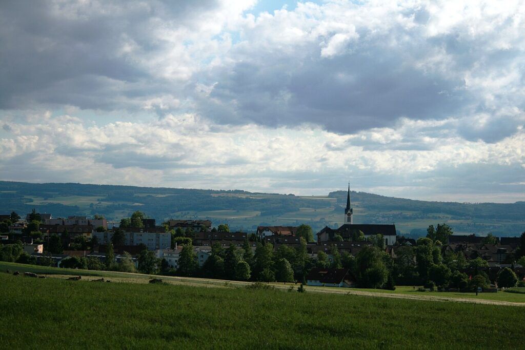 Berikon am Mutschellen im Kanton Aargau mit Kirche, umgeben von Wiesen und Hügellandschaft
